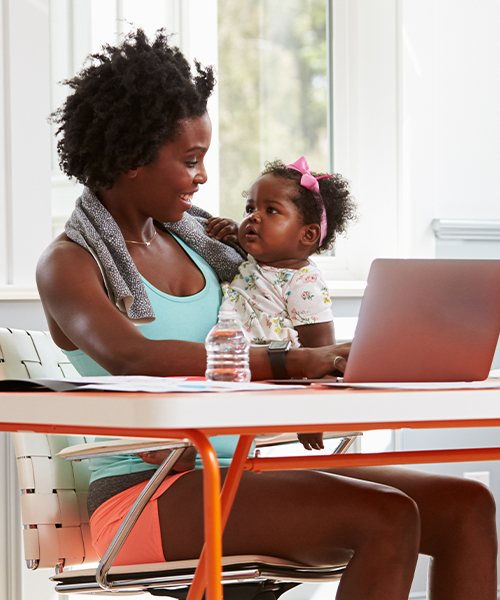 Woman holding daughter at computer